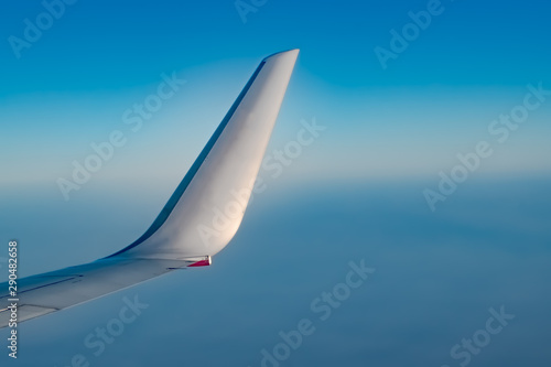 Winglet of Airplane from window, at high Altitude with crystal clear Blue Sky photo