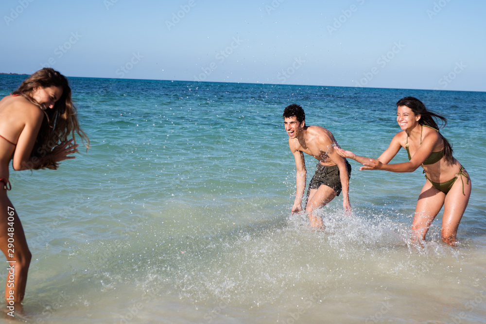 Boy and girl splashing each other in the sea Boy and girl splashing each other in the sea