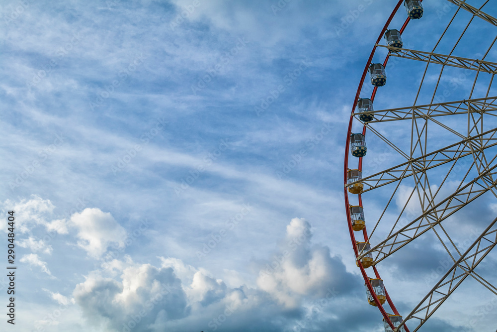 ferris wheel against cloudy sky