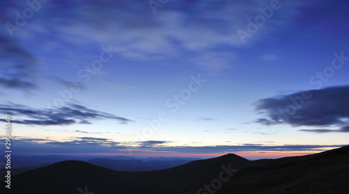Amazing sky before sunrise in the Carpathians, silhouettes of mountains on the horizon