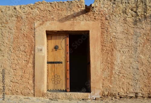Small stone hut with a wooden door in the dessert oasis of Chebika © OlegMit