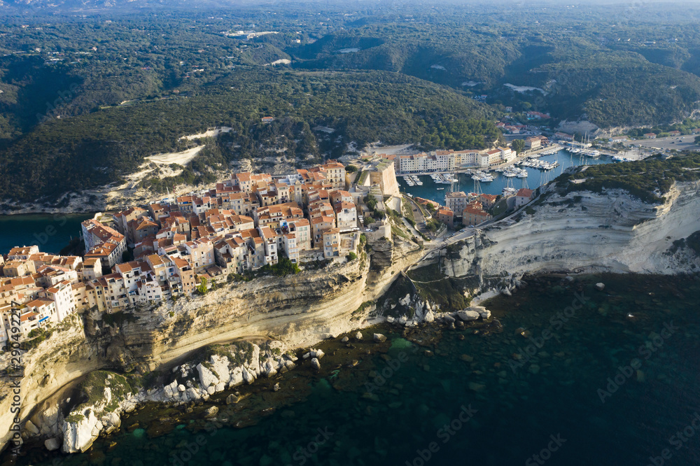 View from above, stunning sunset that illuminates the beautiful village of Bonifacio built on a limestone cliff. Bonifacio is a commune at the southern tip of the island of Corsica, France.
