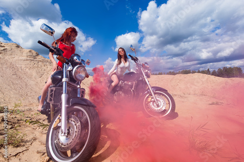 Fototapeta Naklejka Na Ścianę i Meble -  two sensual woman on motorbikes with red smoke