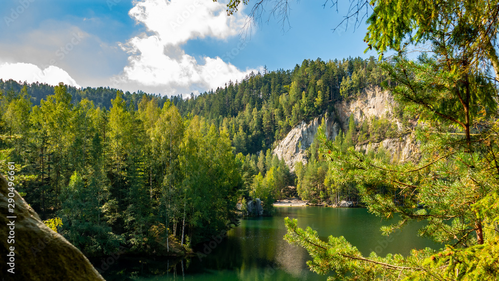 Lake and ancient pines growing between them located in rock city Adrspach, National park of Adrspach, Czech Republic 