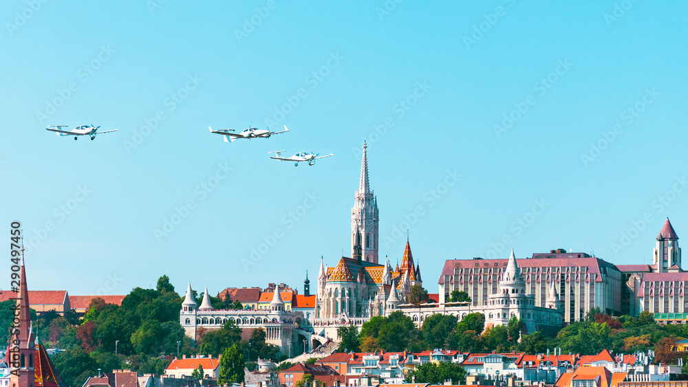 Obraz premium View of the Fisherman's Bastion in Budapest with old airplanes flying over Buda.