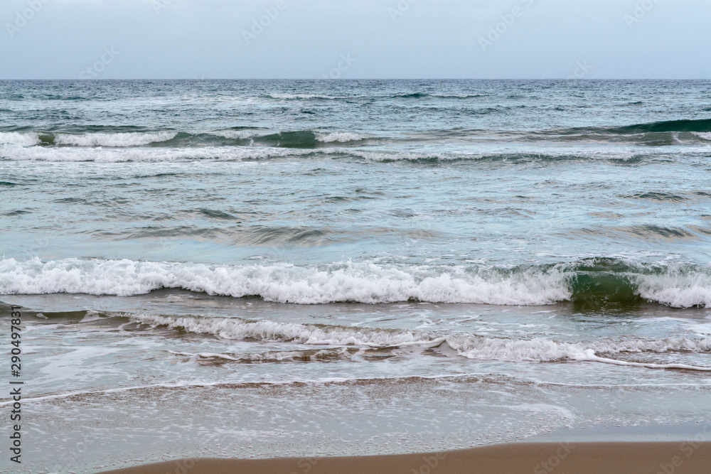 Blue sea water waves and sandy beach
