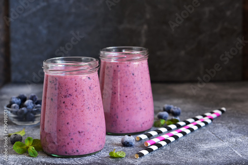Purple smoothies with blueberries on the kitchen table. Detox menu.