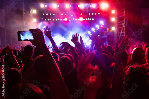People taking photographs with touch smart phone during a music entertainment public concert