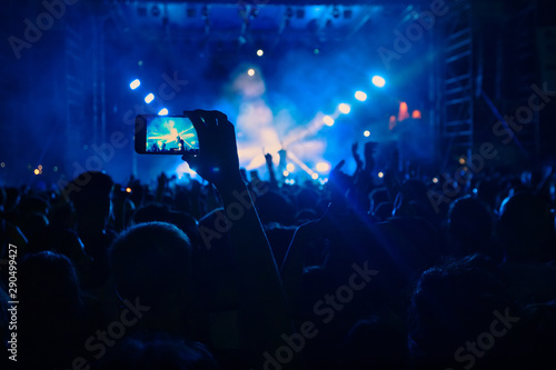 People taking photographs with touch smart phone during a music entertainment public concert