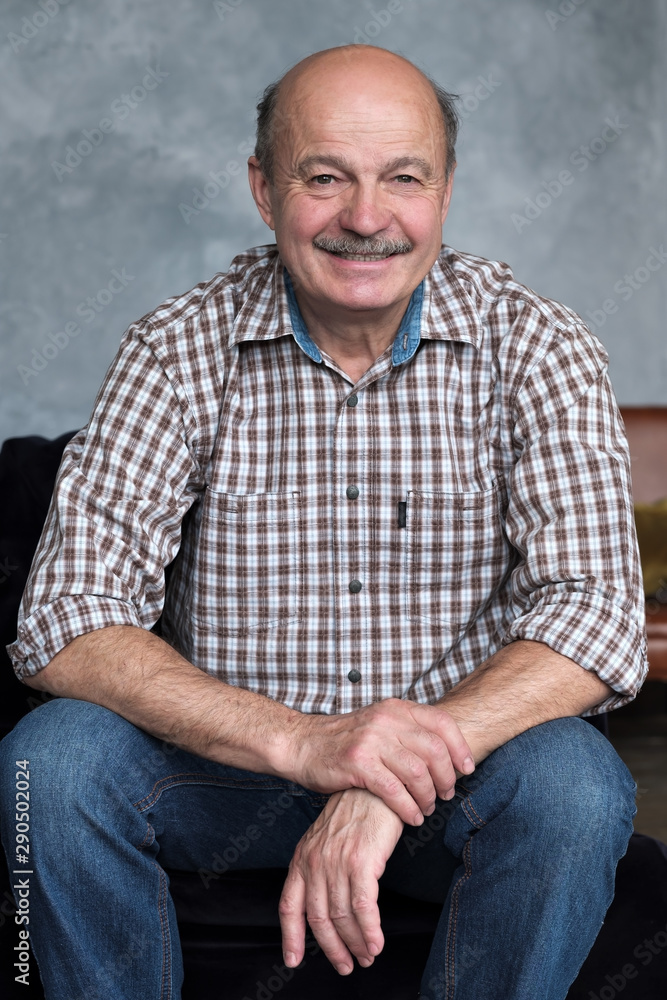 Portrait of senior hispanic man relaxing in sofa at home. Confident facial human emotion. Vertical orientation Portrait of senior hispanic man relaxing in sofa at home. Confident facial human emotion. Vertical orientation