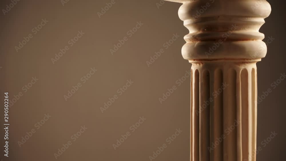 Single ancient greek column rotating slowly on brown background, copy space text area Single ancient greek column rotating slowly on brown background, copy space text area