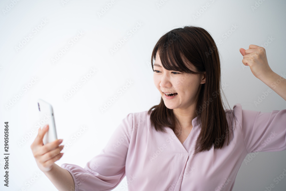 Angry business woman talking on smart phone against white wall Angry business woman talking on smart phone against white wall