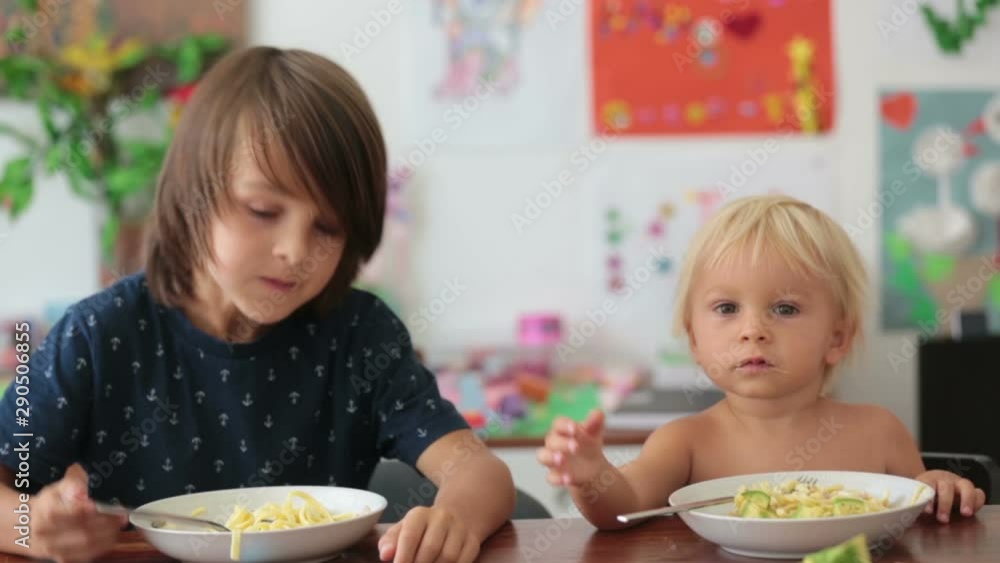 Sweet toddler boy, eating spaghetti at home, making a mess and having fun playing with them Sweet toddler boy, eating spaghetti at home, making a mess and having fun playing with them