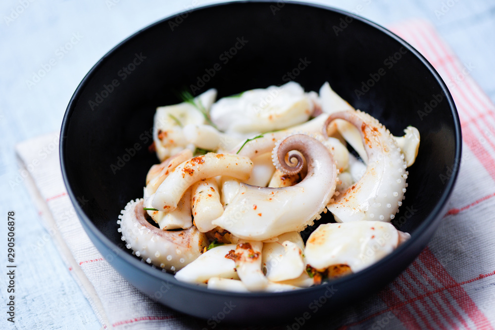 squid salad bowl with herbs and spices sauce seafood on dining table - Tentacles octopus cooked appetizer food cooked in the restaurant squid salad bowl with herbs and spices sauce seafood on dining table - Tentacles octopus cooked appetizer food cooked in the restaurant