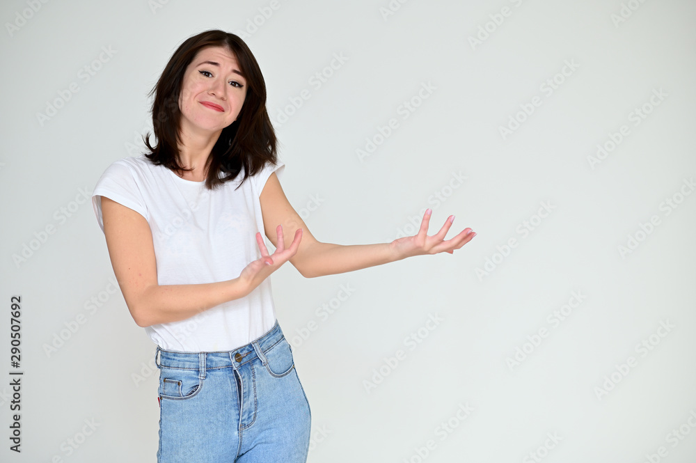 Portrait of a pretty asian brunette girl with black hair in a white t-shirt and blue jeans on a white background. It stands right in front of the camera, with emotions in various poses. Portrait of a pretty asian brunette girl with black hair in a white t-shirt and blue jeans on a white background. It stands right in front of the camera, with emotions in various poses.