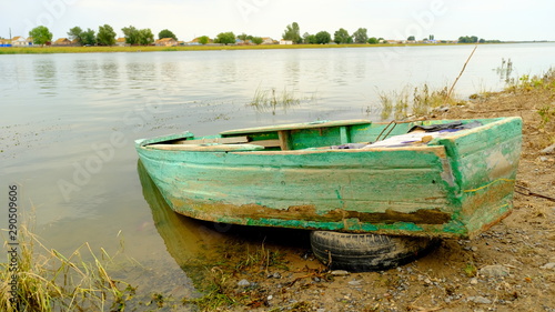 Fototapeta Naklejka Na Ścianę i Meble -   Old wooden fishing boat by the river in a Russian village
