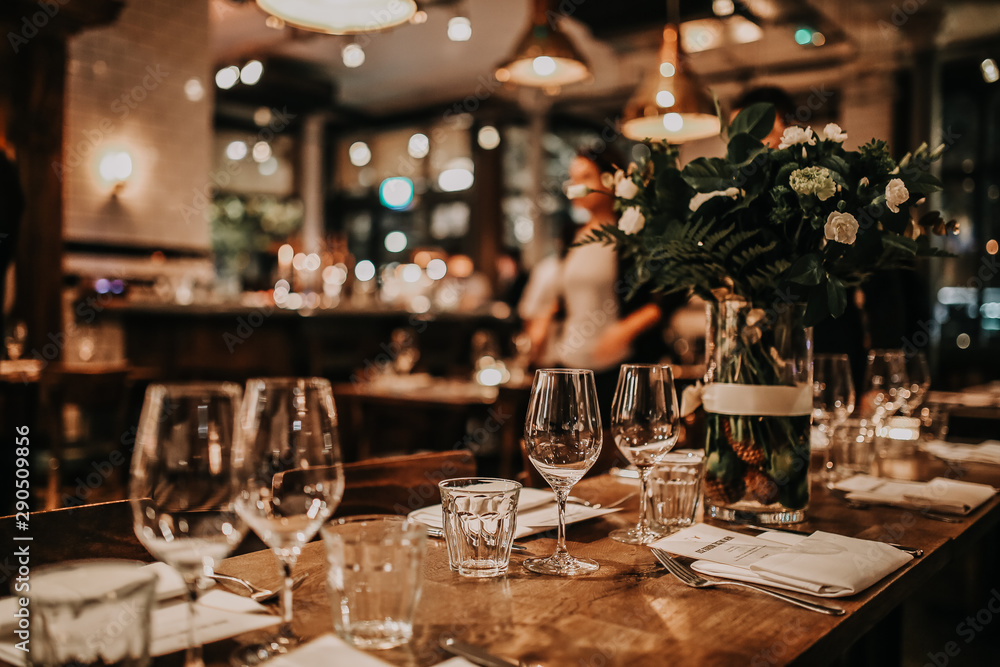 Elegant table set up for a romantic dinner. Concept of catering, hospitality and private dining. Selective focus on the glassware. - obrazy, fototapety, plakaty 