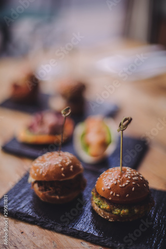 A close up shot of a selection of canape dishes. Concept of catering, hospitality and lifestyle. Small snacks and nibbles served on black slates for a private reception.