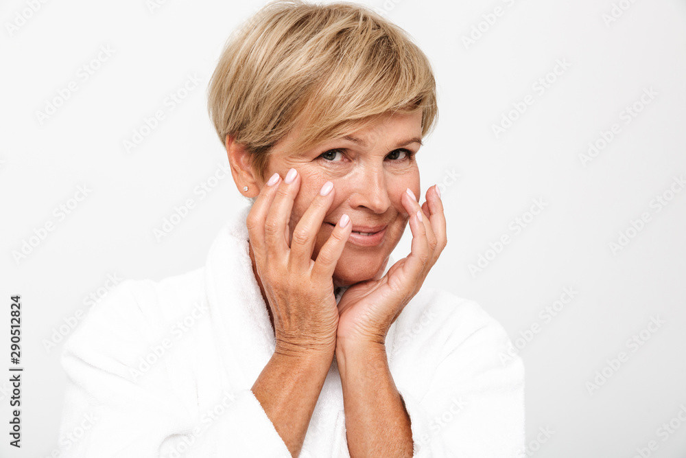 Image of wrinkled adult woman wearing white housecoat touching her face Image of wrinkled adult woman wearing white housecoat touching her face