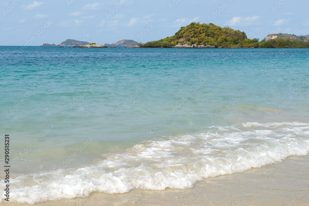 Beautiful sand beach and tropical sea at sunny summer day. Distant tropical island on the horizon. Travel vacation relax concept.