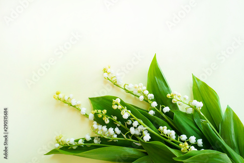 White flowers of lily of the valley on a warm light background. close-up. Copy space. selective focus