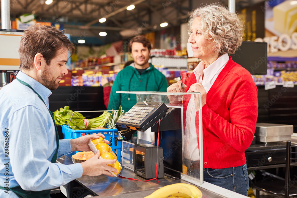 Kundin an der Supermarkt Kasse schaut auf Kassierer Stock Photo Adobe Stock