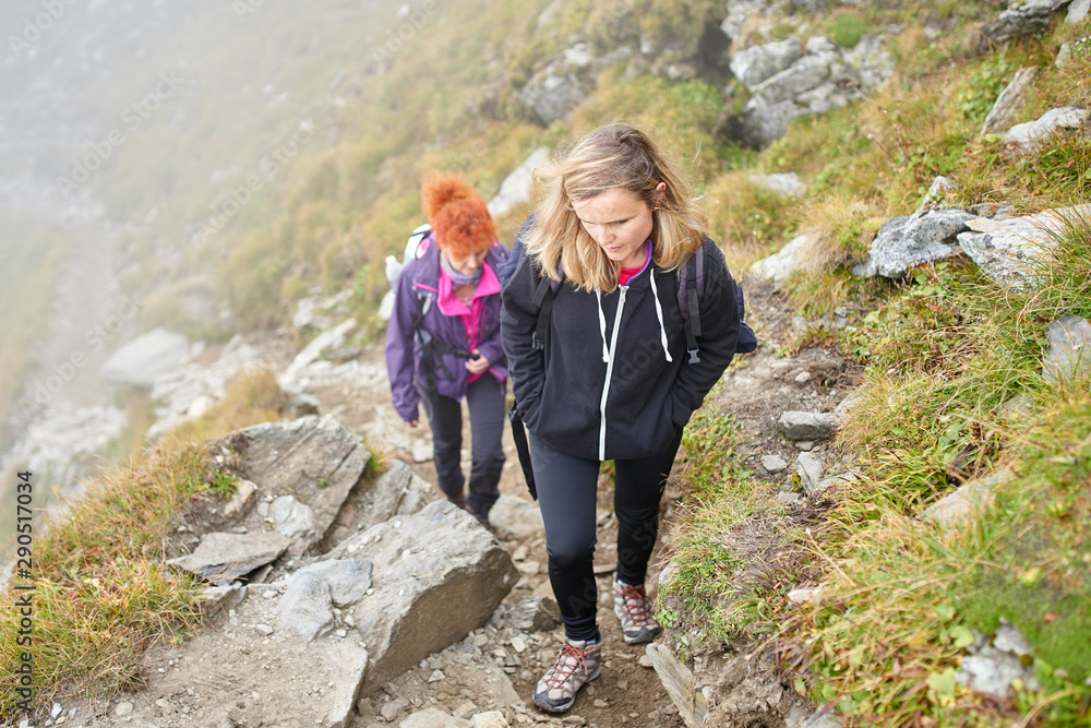 Naklejka premium Backpacker ladies hiking on a trail