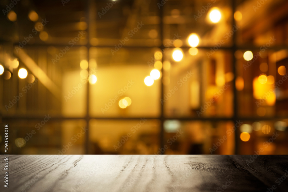 Fototapeta premium top of black table with blur window of blur pub or bar with party night light interior background
