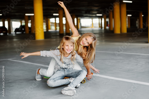 Two beautiful girls having fun and playing in the parking lot. Street photo shoot