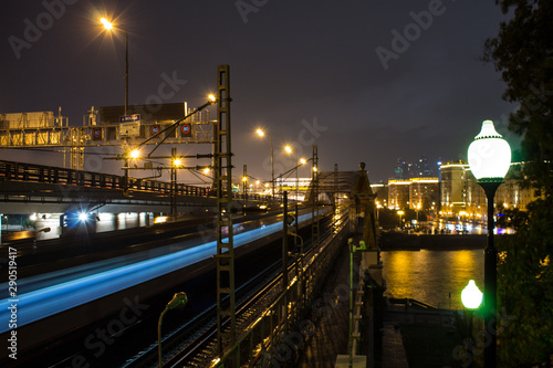 urban view of the railway via the metal bridge next to the freeway in the background of the night sky in Moscow Russia