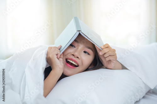 The girl lying in bed listening to music and reading books...