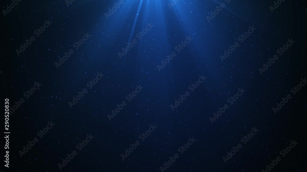 Computer generated footage of particles moving around while light flares from above. Footage creates the illusion of light passing through deep ocean water.