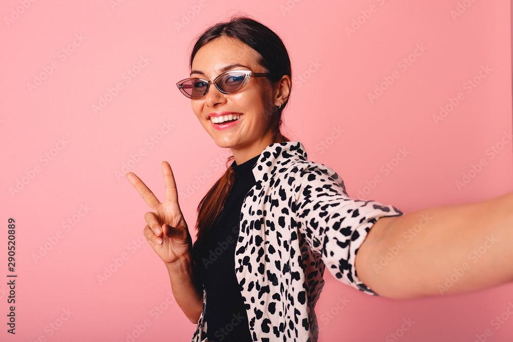Image of charming young woman smiling and taking selfie photo isolated over yellow background.Lovely playful young woman taking selfie with mobile phone Image of charming young woman smiling and taking selfie photo isolated over yellow background.Lovely playful young woman taking selfie with mobile phone
