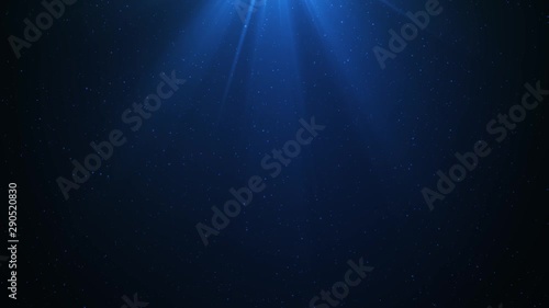 Computer generated footage of particles moving around while light flares from above. Footage creates the illusion of light passing through deep ocean water. photo