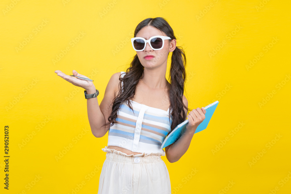 Beautiful female students hold notebooks and pens in the hands of creative designs on a yellow background. Beautiful female students hold notebooks and pens in the hands of creative designs on a yellow background.