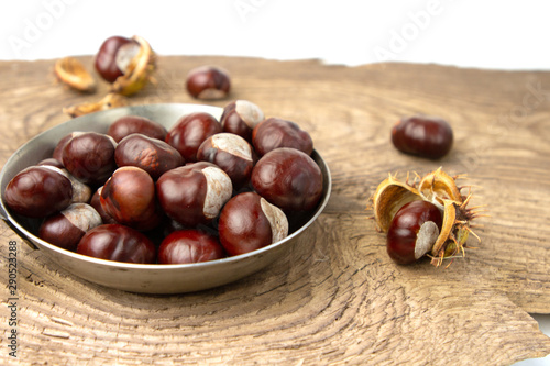 chestnuts in a pan on a wooden board isolated on white background