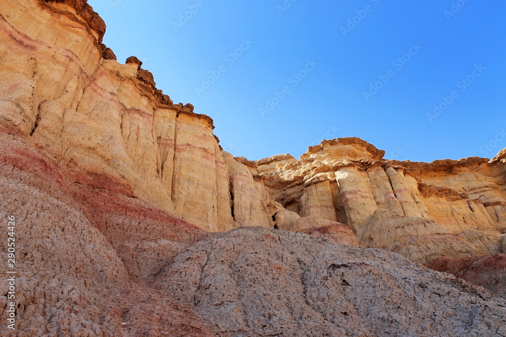 Yellow and red coloured cliffs of Tsagaan Suvraga « white stupa » in the Gobi desert on a bright sunny day, Dundgovi Province, Mongolia.