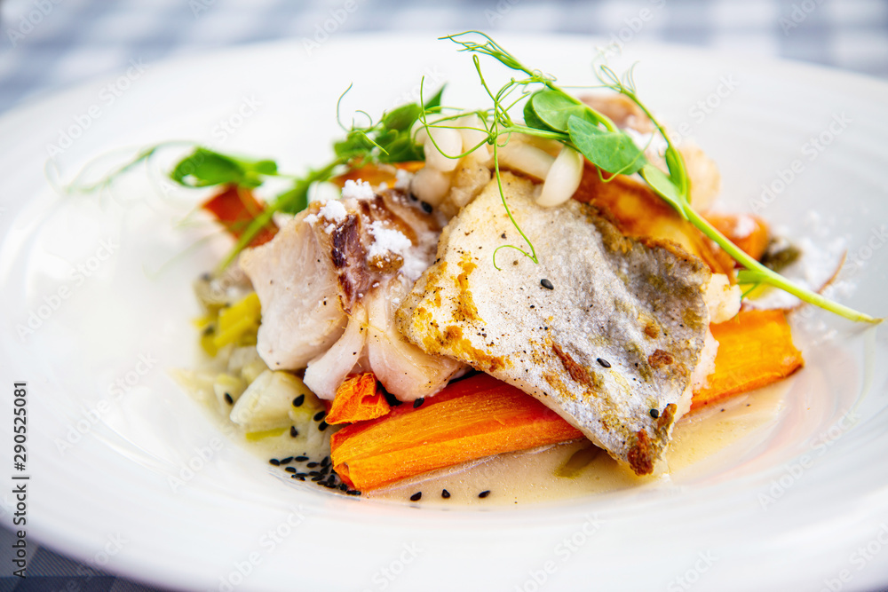 Delicious fillet of cod fish with carrots, leeks and mushrooms in white plate ready to be served Delicious fillet of cod fish with carrots, leeks and mushrooms in white plate ready to be served