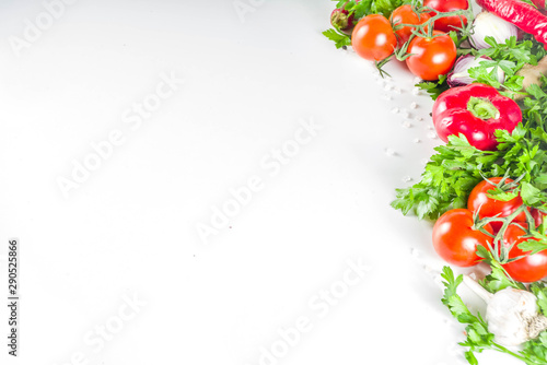 Cooking background with fresh vegetables and herbs. Healthy clean eating vegetarian food, diet nutrition concept. Various fresh veggie ingredients for salad or stew, white table, top view copy space