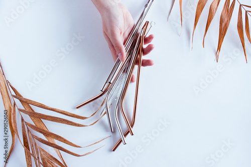 Metal straws in a hand on white background. Zero waste. Flat lay