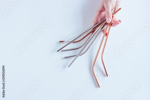 Metal straws in a hand on white background. Zero waste. Flat lay