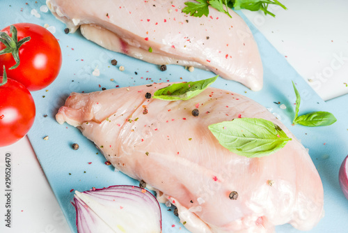 Raw chicken fillet with spices and herbs on cutting board. Cooking chicken breast background. Preparation food, Diet healthy meat.