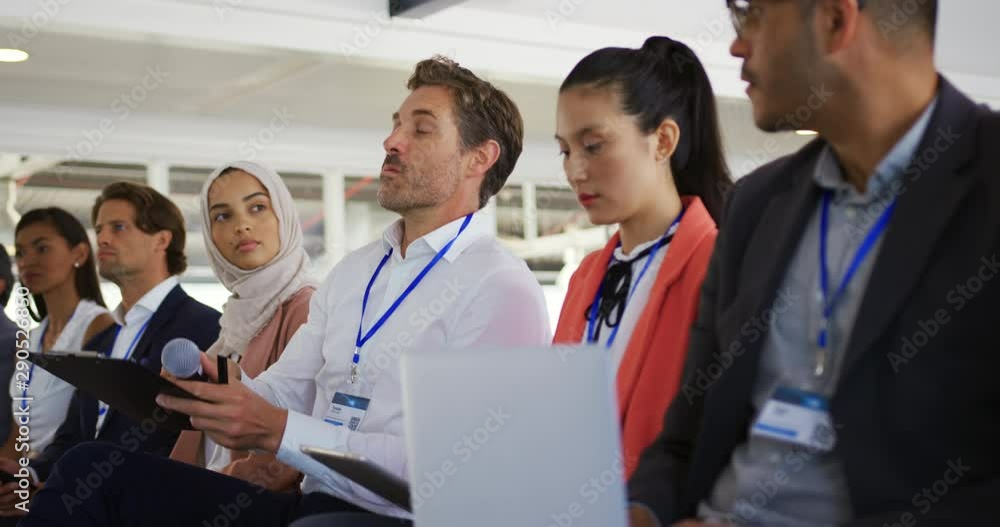 Male audience member at a business conference asking a question Male audience member at a business conference asking a question