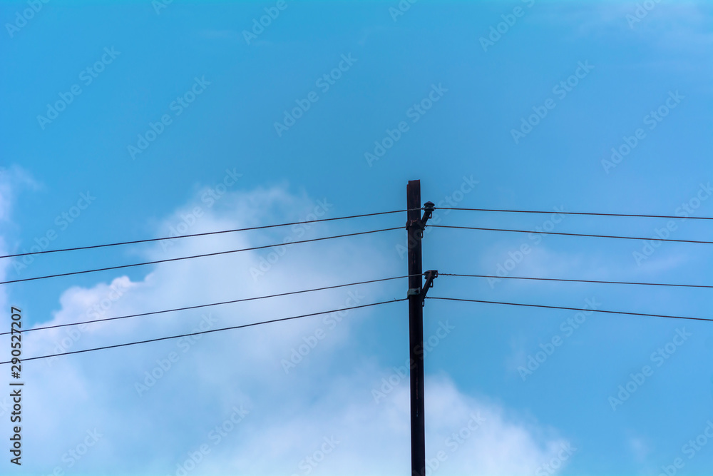 Horizontal black electric pole with blue & white sky background Horizontal black electric pole with blue & white sky background
