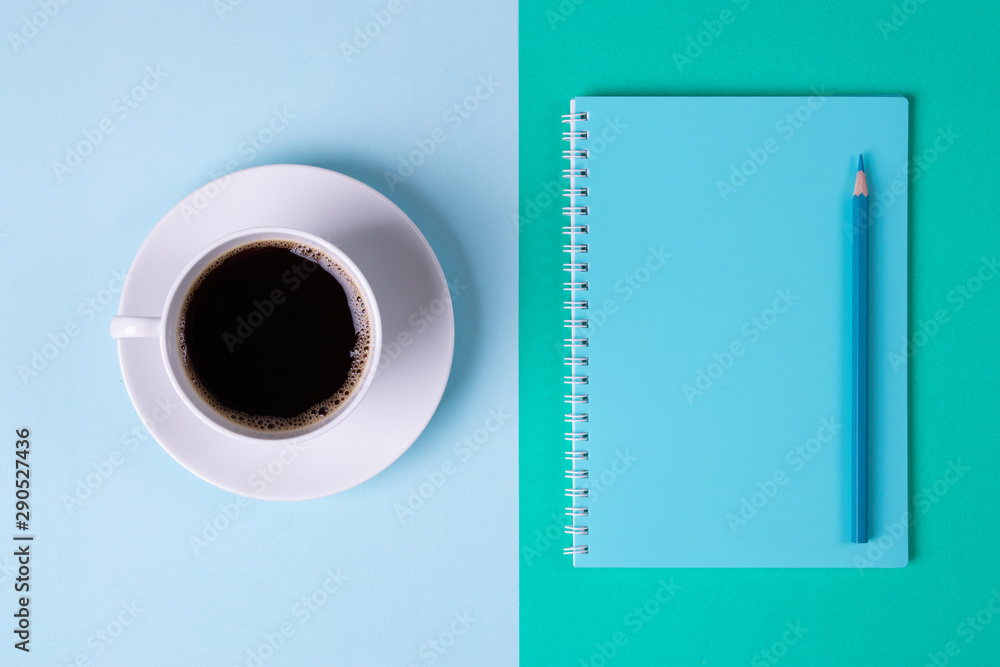 Teacher day concept. Black Coffee and blue notebook on pastel blue and green table background. Teacher day concept. Black Coffee and blue notebook on pastel blue and green table background.