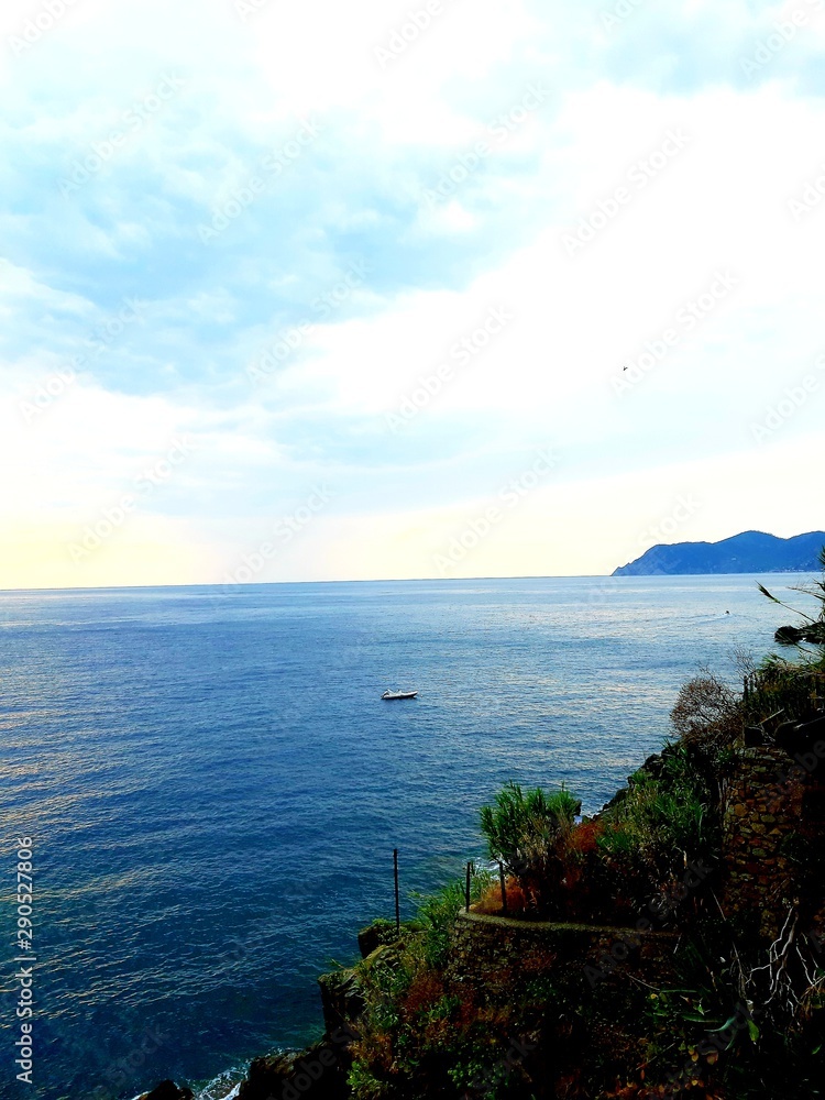 Liguria, Italy - 09/15/2019: Travelling around the ligurian seaside in summer days with beautiful view to the famous places. An amazing caption of the water and the sky reflection with blue sky.