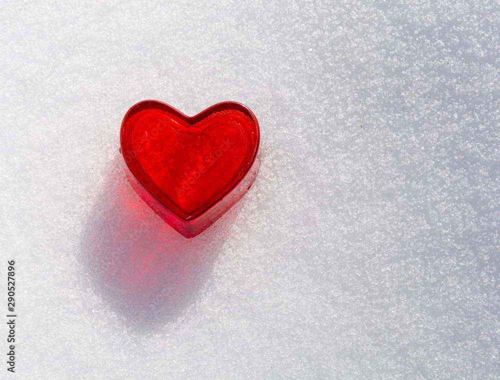 decorative little red heart in the snow with view from above