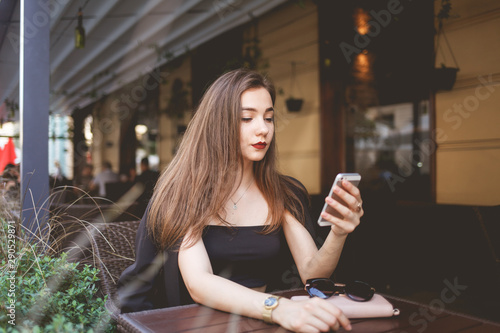 Beautiful girl uses a smartphone to communicate on the network. Portrait of a beautiful woman with a phone