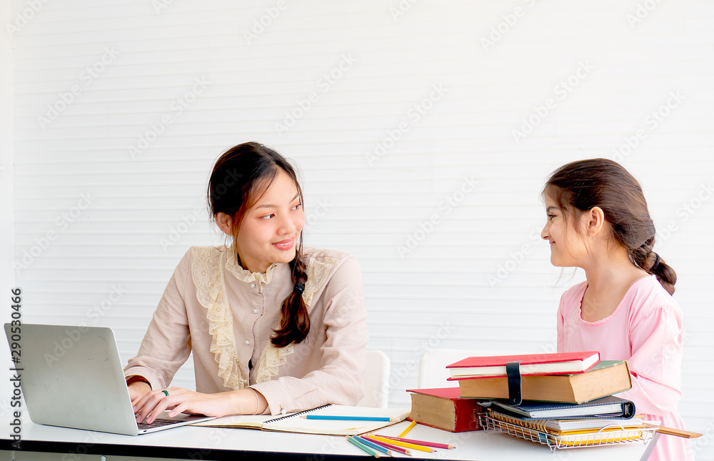 Beauty teen girl is working with laptop and look at to her sister with smiling. Beauty teen girl is working with laptop and look at to her sister with smiling.