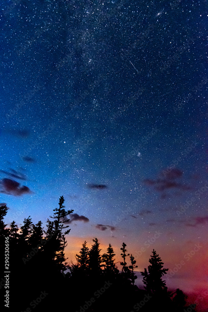 View of the milky way galaxy in the blue sky with clouds above the trees View of the milky way galaxy in the blue sky with clouds above the trees